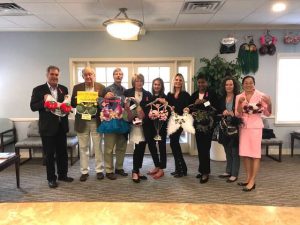A group of providers holding up bras that they designed.