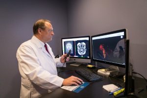 A physician looking at the results of a scan.